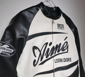 Black and white leather jacket with branding on a gray background