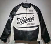 Black and white leather jacket with 'Leon Dore' branding on a gray background